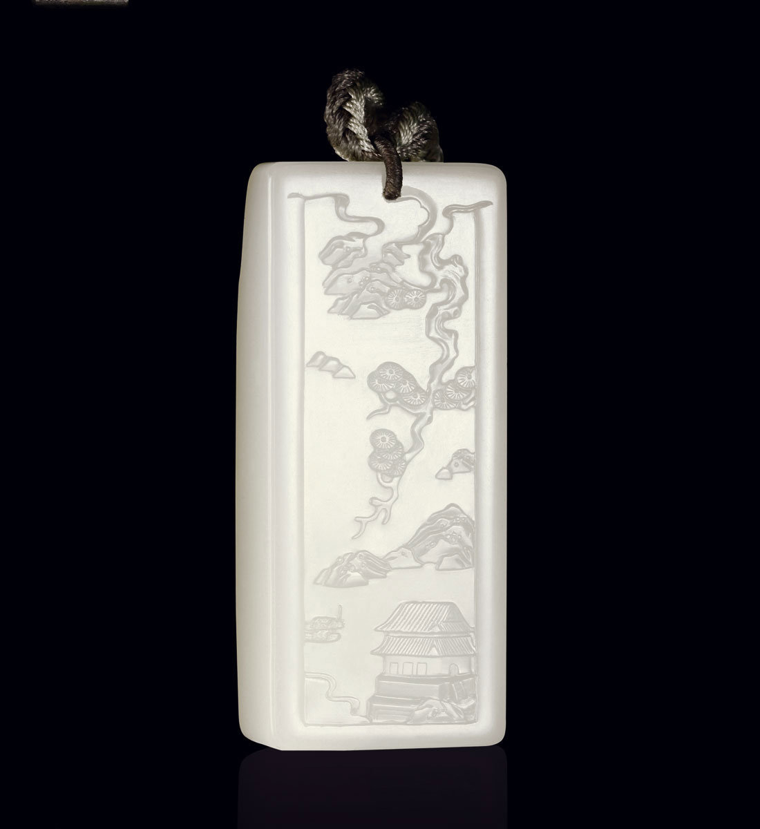 牌為白玉質,略有泛青,但油性較佳,質亦細潤,且背后留有滿皮,尤為難得。牌型為長方形,正面深浮雕法琢制山水,山石嶙峋,老松繁茂,煙霞飄渺,猶若水天一色,其仙境奇景,令人心生向往。此牌意境清幽,布局疏密得當,題材典雅,清雅多姿,別生一種清遠秀逸之氣,文人之氣甚濃。