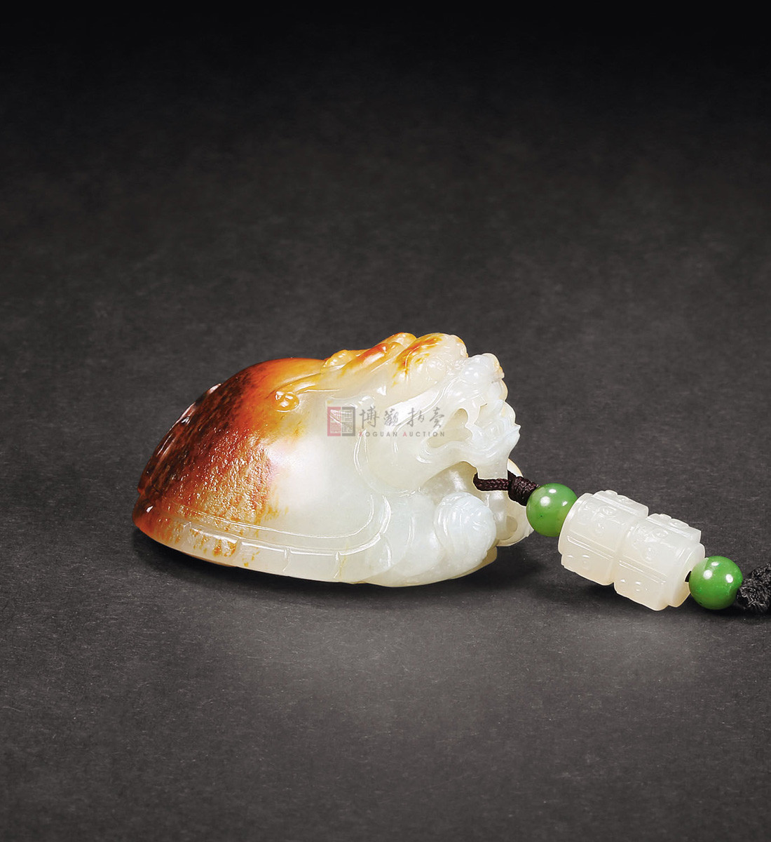 这件作品的设计较为巧妙,利用沁入玉料之中的黄褐色,整体设计为一只龙龟,点点褐色犹若龟壳之斑点,具厚重老气之感。范佰成,海派玉雕名家,江苏省徐州市人,2003年在上海创办石道居个人玉雕工作室,擅长动物、花鸟、人物及仿古件玉雕的设计与雕刻。